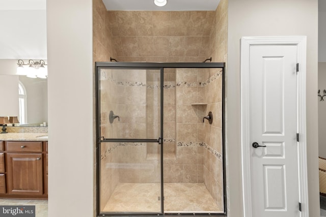bathroom with a shower stall and vanity