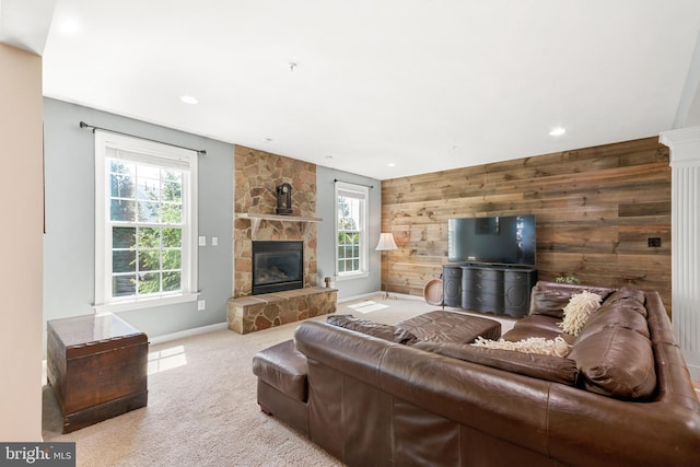 carpeted living area with a fireplace, wood walls, an accent wall, recessed lighting, and baseboards