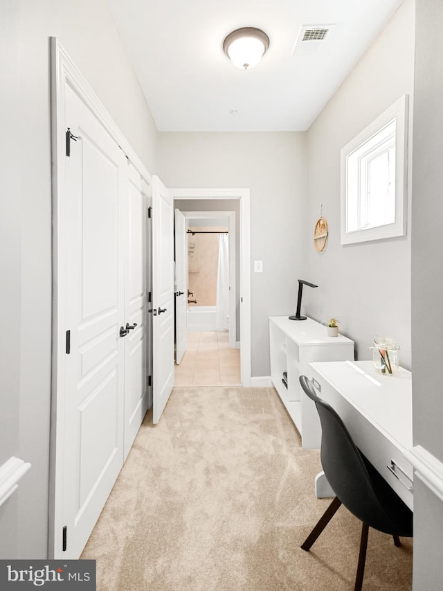 home office with light tile patterned floors, baseboards, light carpet, and visible vents