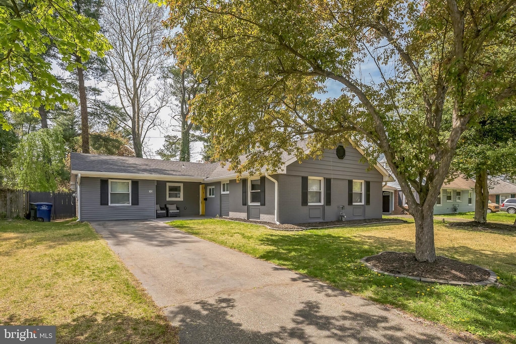 ranch-style house with fence, a front yard, aphalt driveway, and brick siding