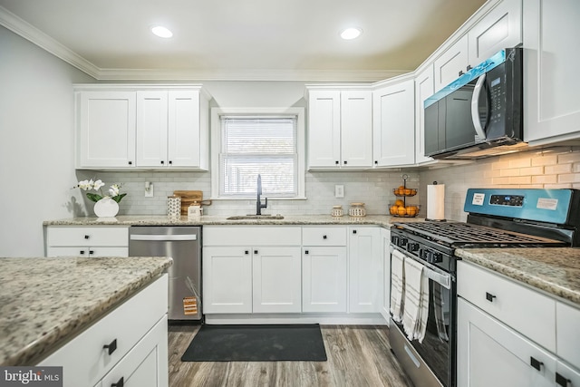 32 Meadowlark Ln, Willingboro, NJ 08046 - kitchen featuring crown molding, white cabinets, a sink, stainless steel appliances, and wood finished floors