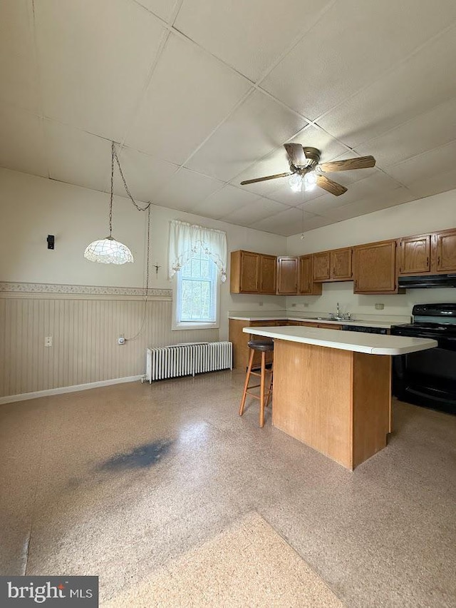 3660 Ginter Morann Hwy, Houtzdale, PA 16651 - kitchen with black / electric stove, a center island, wainscoting, radiator heating unit, and under cabinet range hood