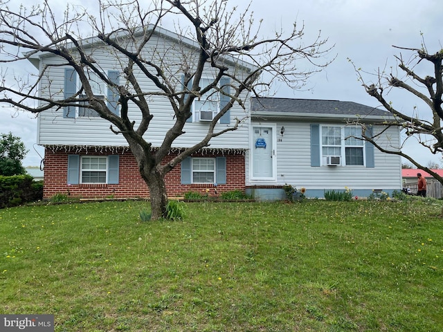 split level home with a front lawn and brick siding