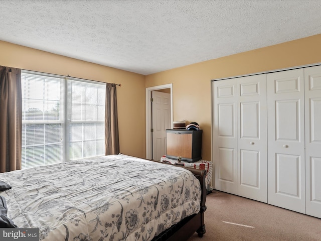 bedroom featuring a closet, carpet flooring, and a textured ceiling