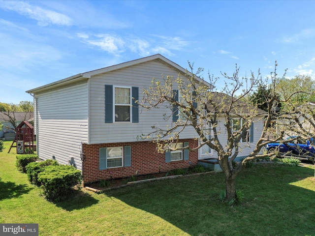 split level home with brick siding and a front lawn