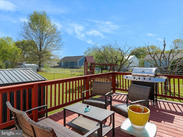 deck with area for grilling, a fenced backyard, outdoor dining area, a playground, and a lawn