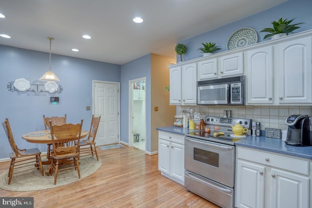 kitchen with white cabinetry, stainless steel appliances, and backsplash