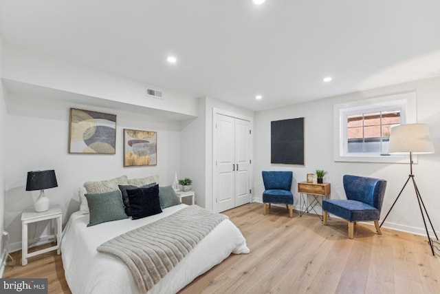 bedroom with visible vents, a closet, and light wood finished floors