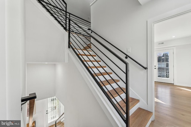 stairs featuring wood finished floors and baseboards