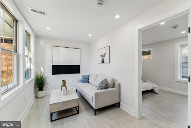 living area with a wealth of natural light, visible vents, and baseboards