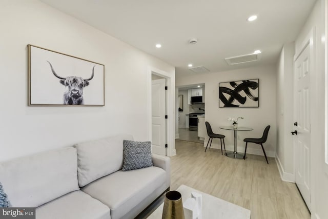 living area featuring attic access, recessed lighting, light wood-style floors, and baseboards