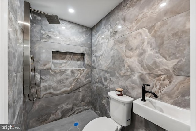 full bathroom with tile walls, tiled shower, and toilet