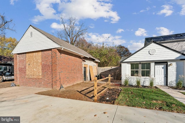 view of property exterior featuring fence and brick siding
