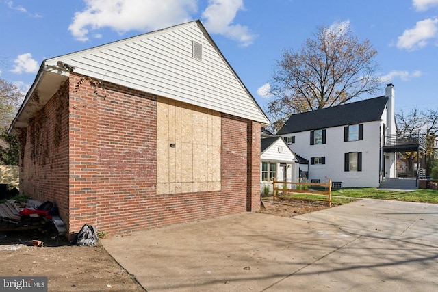 view of side of home featuring a patio and brick siding