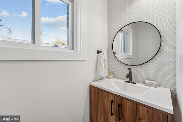 bathroom featuring vanity and backsplash