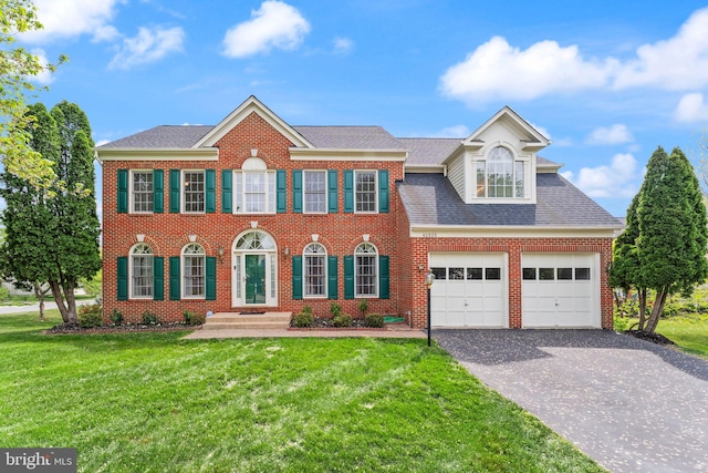 42935 Palliser Ct, Leesburg, VA 20176 - colonial home featuring driveway, a front yard, a shingled roof, and brick siding