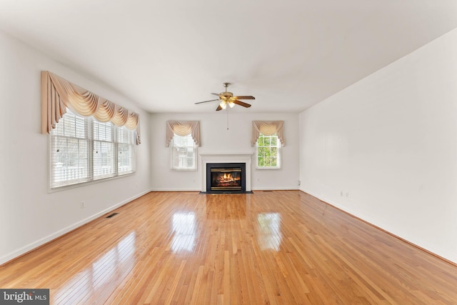 42935 Palliser Ct, Leesburg, VA 20176 - unfurnished living room with light wood-style floors, baseboards, visible vents, a ceiling fan, and a fireplace with flush hearth