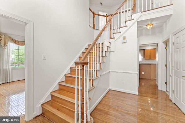 42935 Palliser Ct, Leesburg, VA 20176 - stairs featuring a towering ceiling, wood finished floors, crown molding, and baseboards