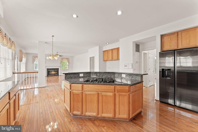 42935 Palliser Ct, Leesburg, VA 20176 - kitchen with appliances with stainless steel finishes, a glass covered fireplace, visible vents, and light wood-type flooring