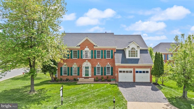 42935 Palliser Ct, Leesburg, VA 20176 - colonial-style house featuring a garage, brick siding, decorative driveway, and a front yard