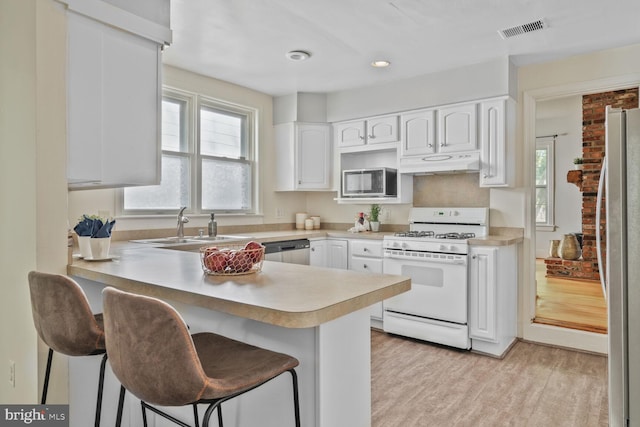 2418 Forest Glen Rd, Silver Spring, MD 20910 - kitchen featuring visible vents, a peninsula, under cabinet range hood, a sink, and appliances with stainless steel finishes