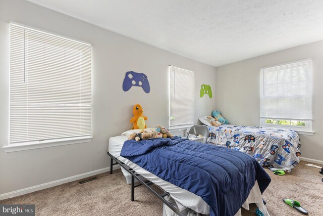 carpeted bedroom featuring baseboards and visible vents