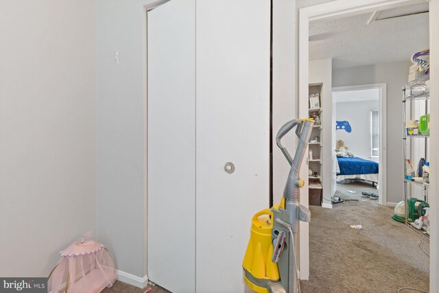 corridor featuring carpet floors, a textured ceiling, and baseboards