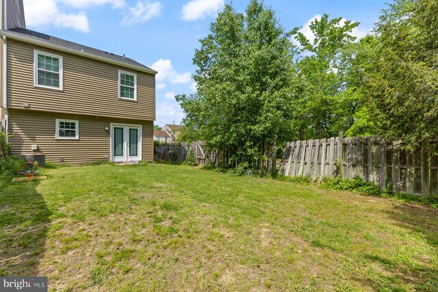 view of yard with a fenced backyard and french doors