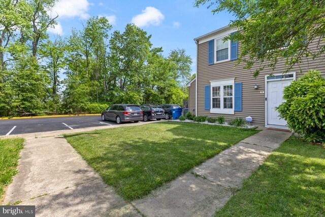 view of front facade featuring uncovered parking and a front yard