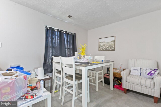 dining area with a textured ceiling and visible vents
