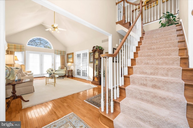 interior space featuring wood-type flooring, high vaulted ceiling, a ceiling fan, visible vents, and french doors