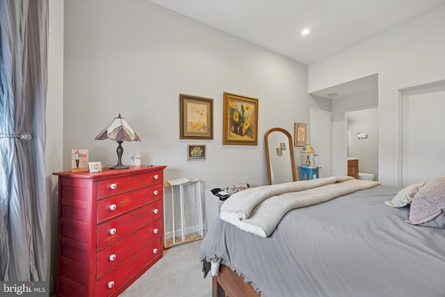 carpeted bedroom featuring ensuite bath and recessed lighting