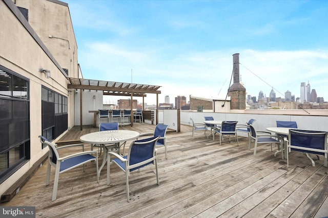 deck featuring outdoor dining space and a view of skyline