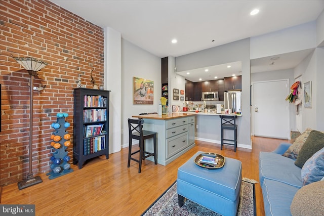 living room featuring light wood-type flooring, baseboards, and recessed lighting
