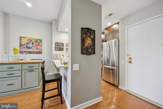 kitchen featuring freestanding refrigerator, light wood-style flooring, recessed lighting, and baseboards