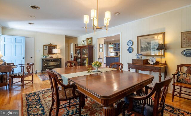 2231 Whays Creek Rd, Reedville, VA 22539 - dining area with crown molding, visible vents, an inviting chandelier, and light wood-style floors