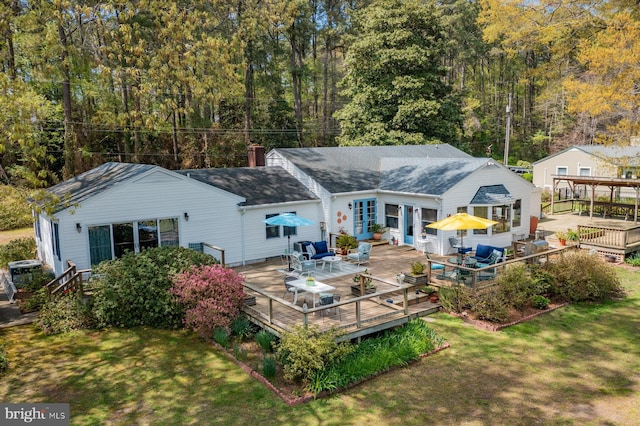 2231 Whays Creek Rd, Reedville, VA 22539 - rear view of house with a deck, a chimney, a yard, a shingled roof, and outdoor dining area