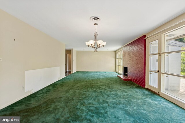 unfurnished dining area with visible vents, a brick fireplace, baseboards, a chandelier, and carpet