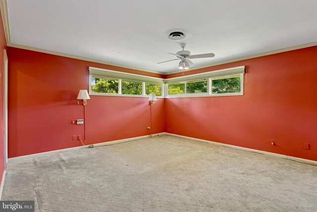 empty room featuring baseboards, ornamental molding, a ceiling fan, and carpet flooring