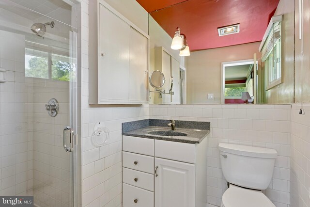 bathroom featuring tile walls, plenty of natural light, and a stall shower