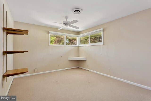 spare room with a ceiling fan, baseboards, and carpet