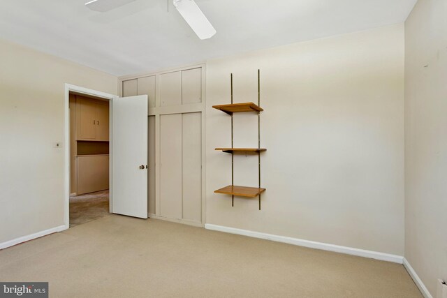 unfurnished bedroom with a ceiling fan, baseboards, light carpet, and a closet