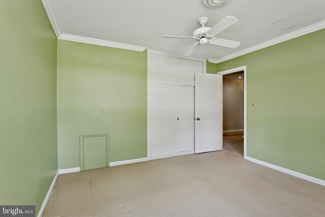 unfurnished bedroom with crown molding, baseboards, a closet, and carpet flooring