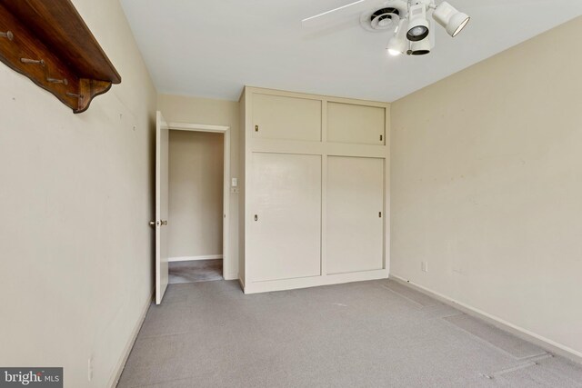 unfurnished bedroom with baseboards, ceiling fan, and light colored carpet