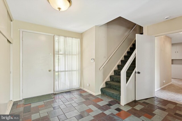 entrance foyer with baseboards and stairway