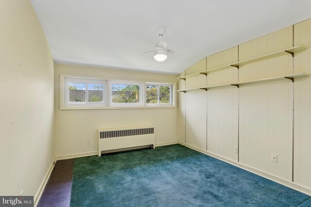 interior space with radiator heating unit, baseboards, carpet, and vaulted ceiling
