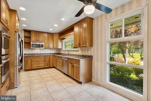 kitchen with open shelves, a sink, appliances with stainless steel finishes, and wallpapered walls