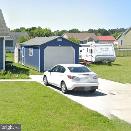 view of front of property with a detached garage, an outdoor structure, a front lawn, and concrete driveway