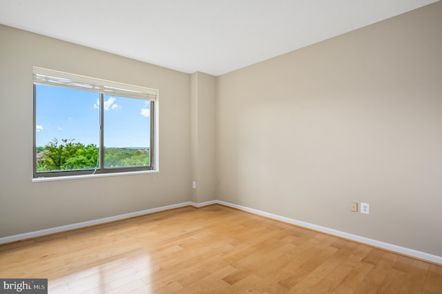 empty room featuring light wood finished floors and baseboards