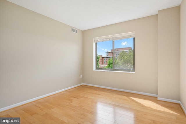 unfurnished room with baseboards and light wood-style floors